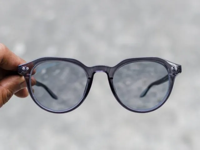 Mans,Hand,Holding,A,Glasses,With,Photochromic,Lenses,On,Grey