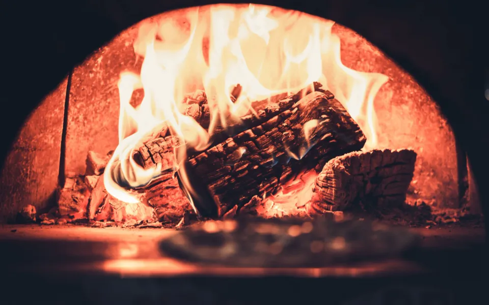 A fireplace with half circle opening, it also has burning wood inside - LasVegasRealEstate.com