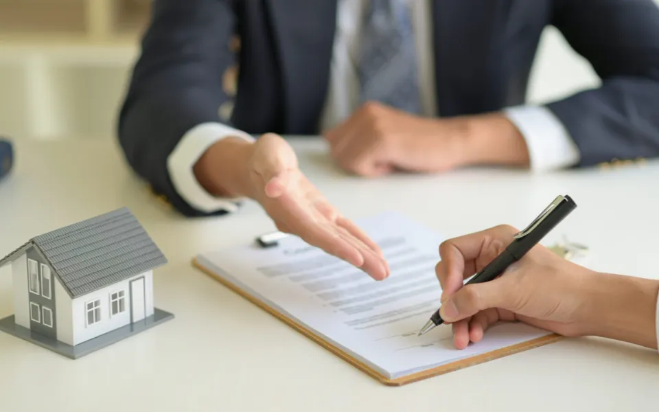 an image with two people that shows one explaining a contract then the other is signing the contract - LasVegasRealEstate.com