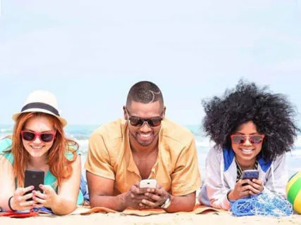 Group of friends wearing sunglasses and smiling on beach