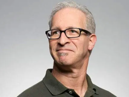 Older man with short gray hair wearing black eyeglasses