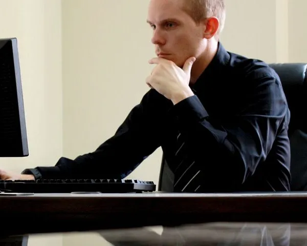 Concerned Business Man at Desk with Computer